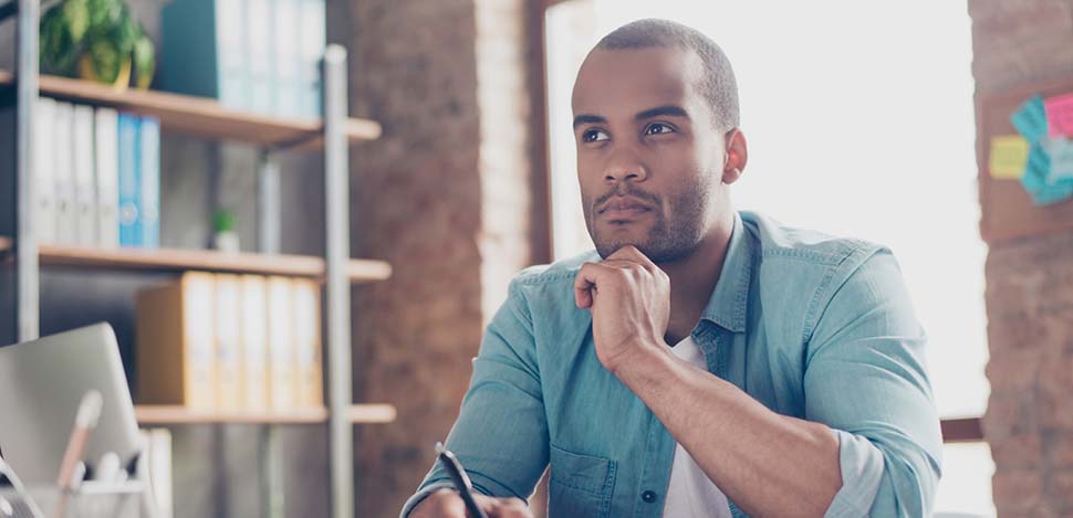 Man sitting at desk contemplating his smoking cessation benefits and which work best