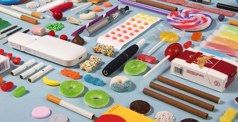 brightly colored candy and flavored tobacco cigarettes layed out on a table