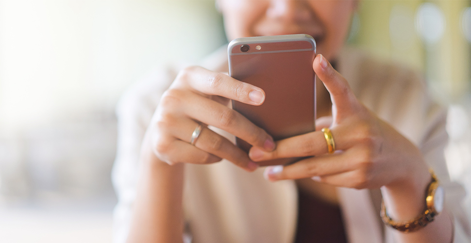 woman sitting at desk using technology to review personalized quit-smoking texts