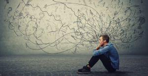 man sitting in front of abstract background reflecting on the link between employee mental health and stress smoking