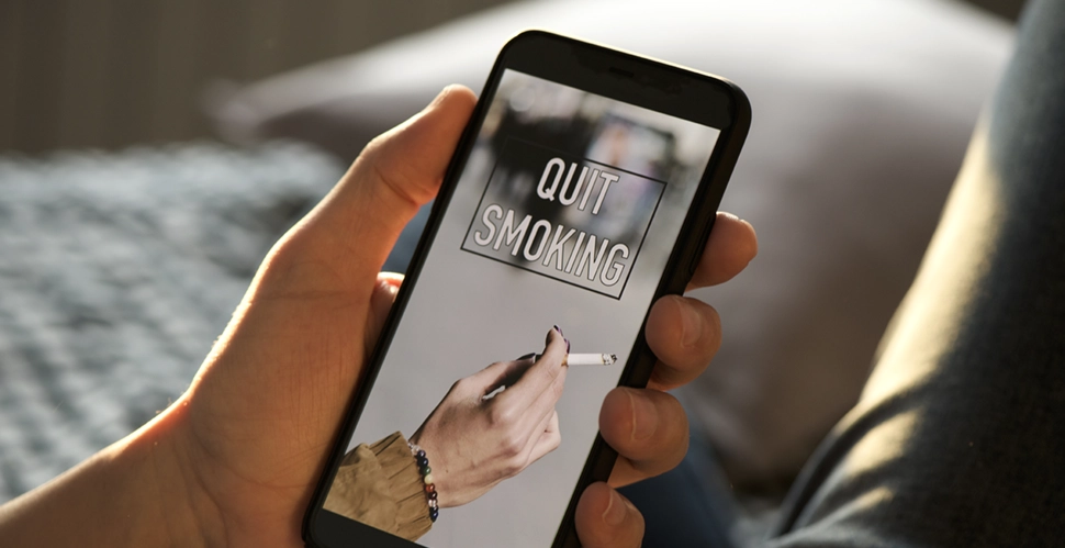hand holding a mobile phone searching for quit-smoking resources