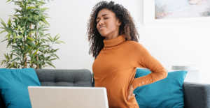 woman working from home with back pain due to musculoskeletal disorders that can impact productivity