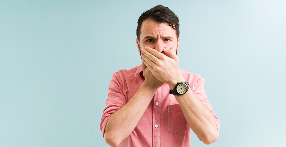 man holding his nose to avoid the smell of thirdhand smoke