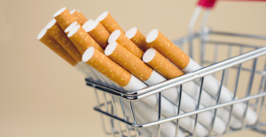 Oversized cigarettes in a shopping cart to illustrate the question do cigarette taxes work